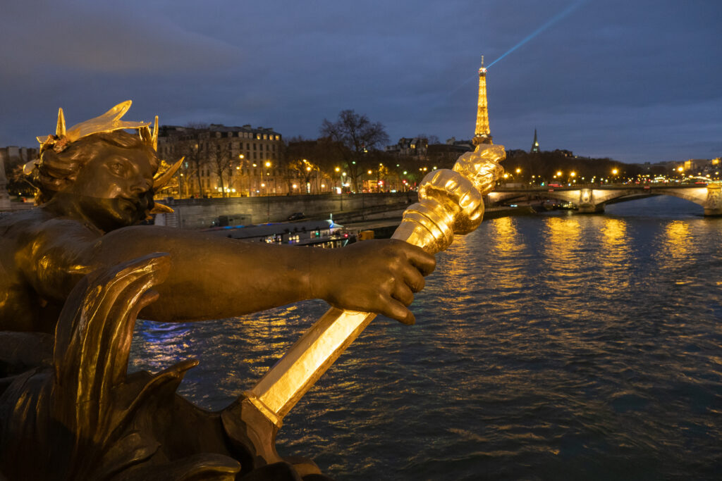 Puente Alejandro III en Paris con la torre Eiffel iluminados